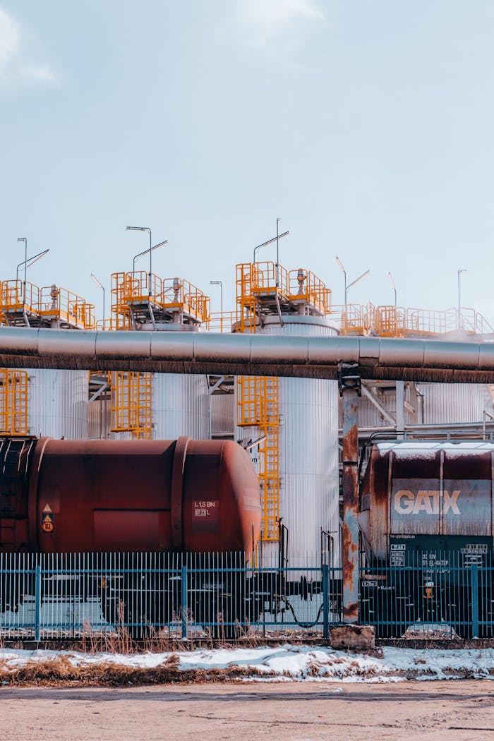 creative-03 Freight trains in front of storage tanks at an industrial site in winter.