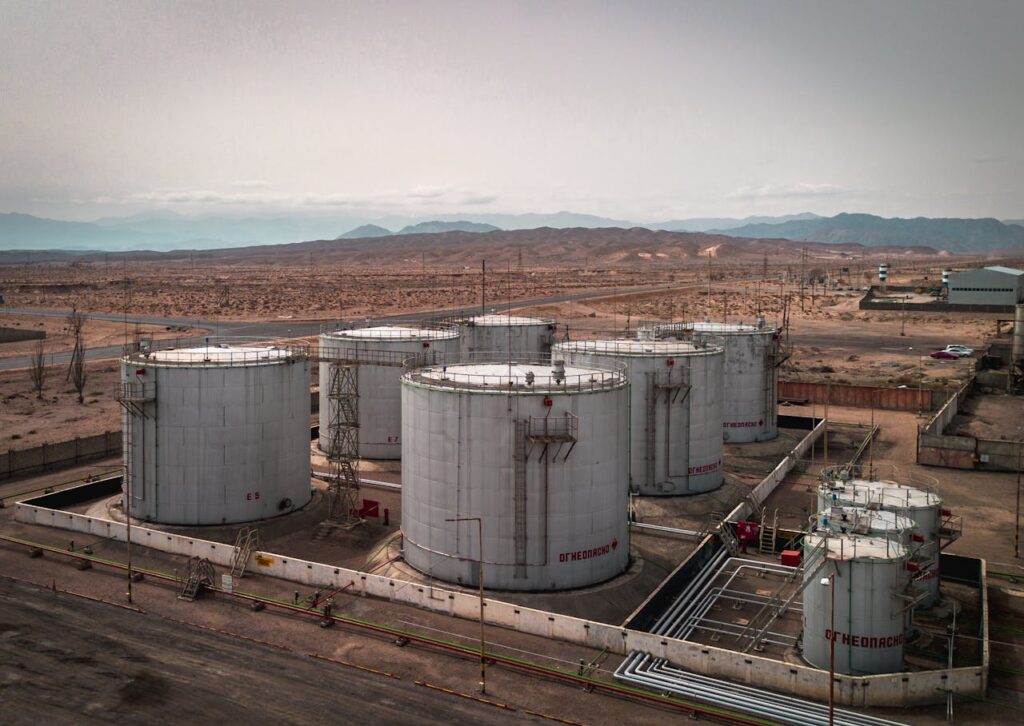 The Art of Drawing Readers In: Your attractive post title goes here Aerial view of large industrial oil tanks in a desert setting with mountains in the distance.